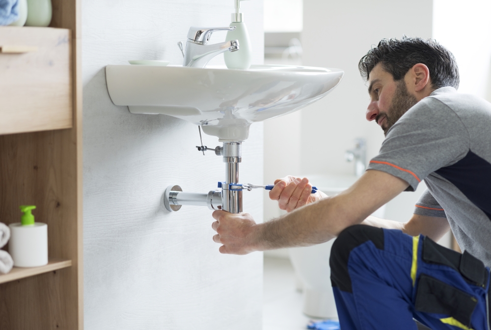 plumber fixing leak in bathroom