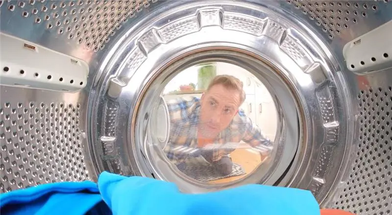 Man looking into the drum of a washing machine