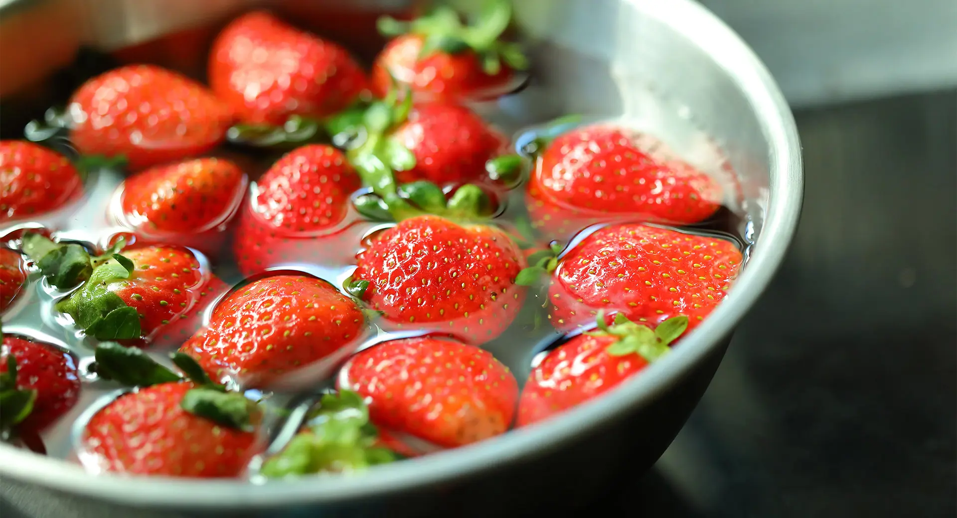 Fresh strawberries being washed in water