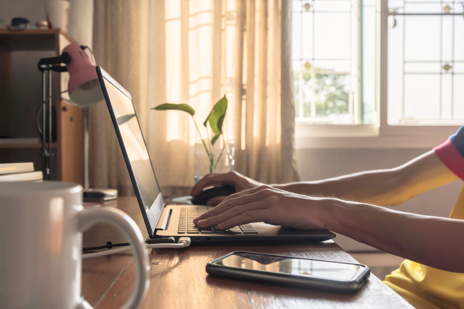 close up of a laptop with someone working from home
                        