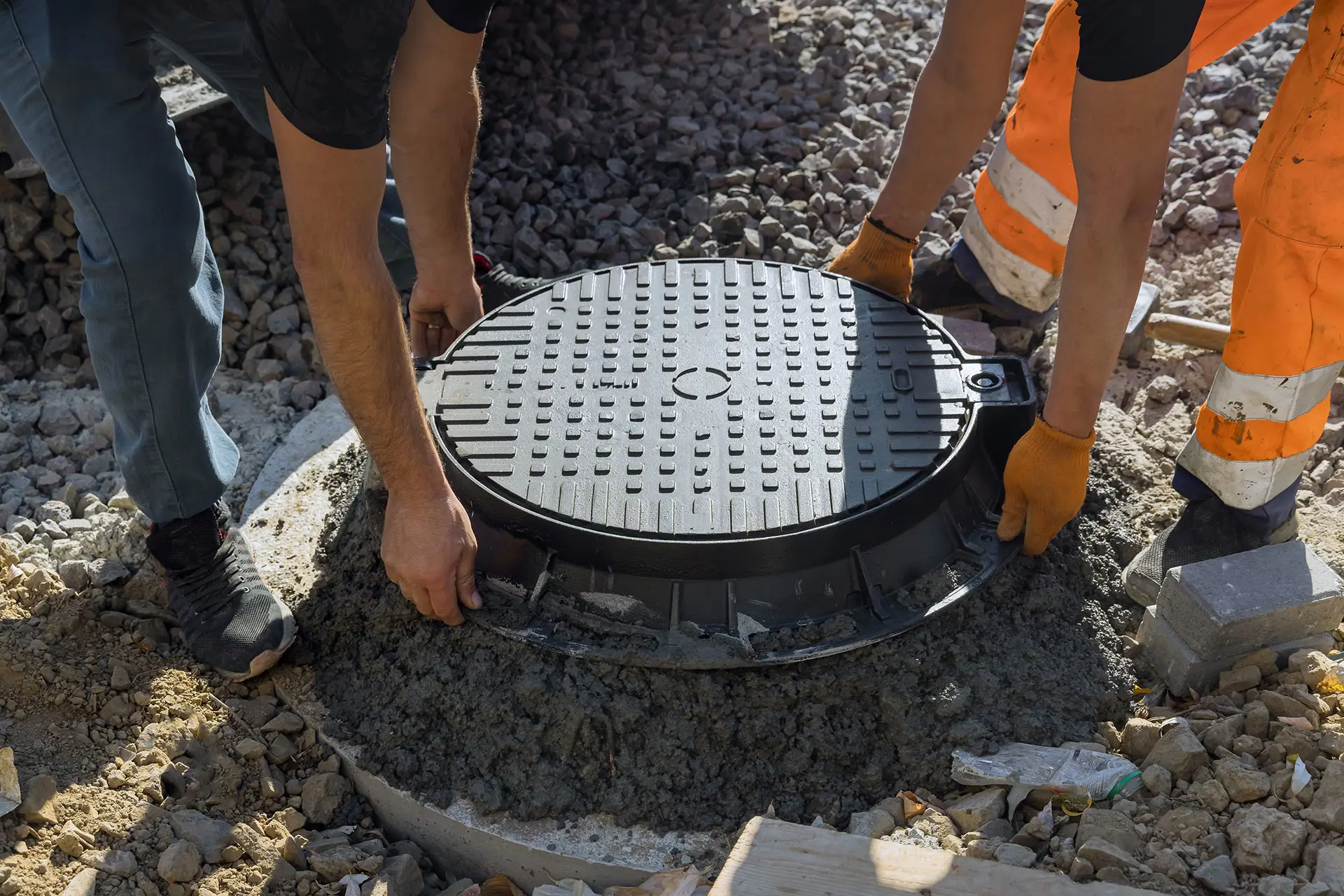 Workers removing a sewer cover
