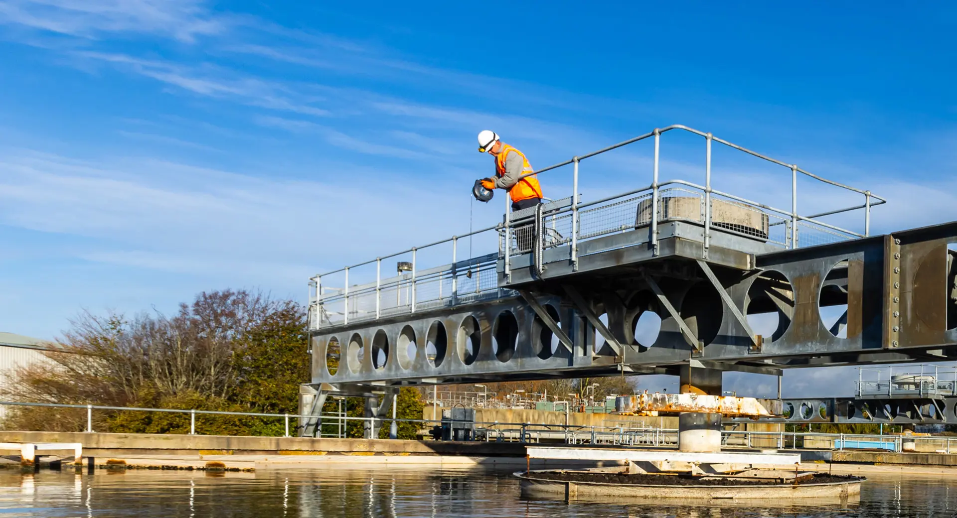 A photo of John Robertson working on a platform pertruding above a body of water