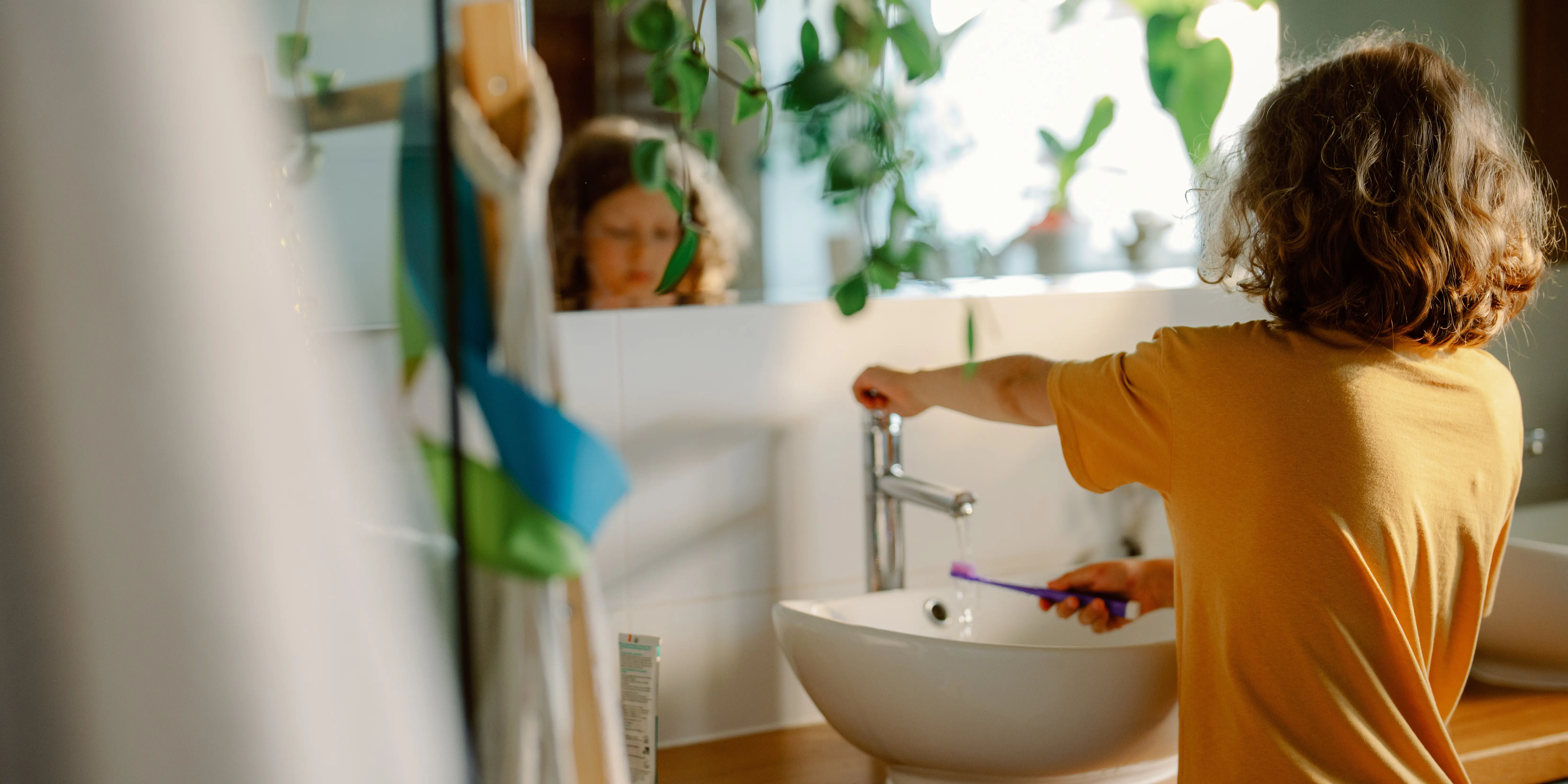 Young child brushing their teeth at home