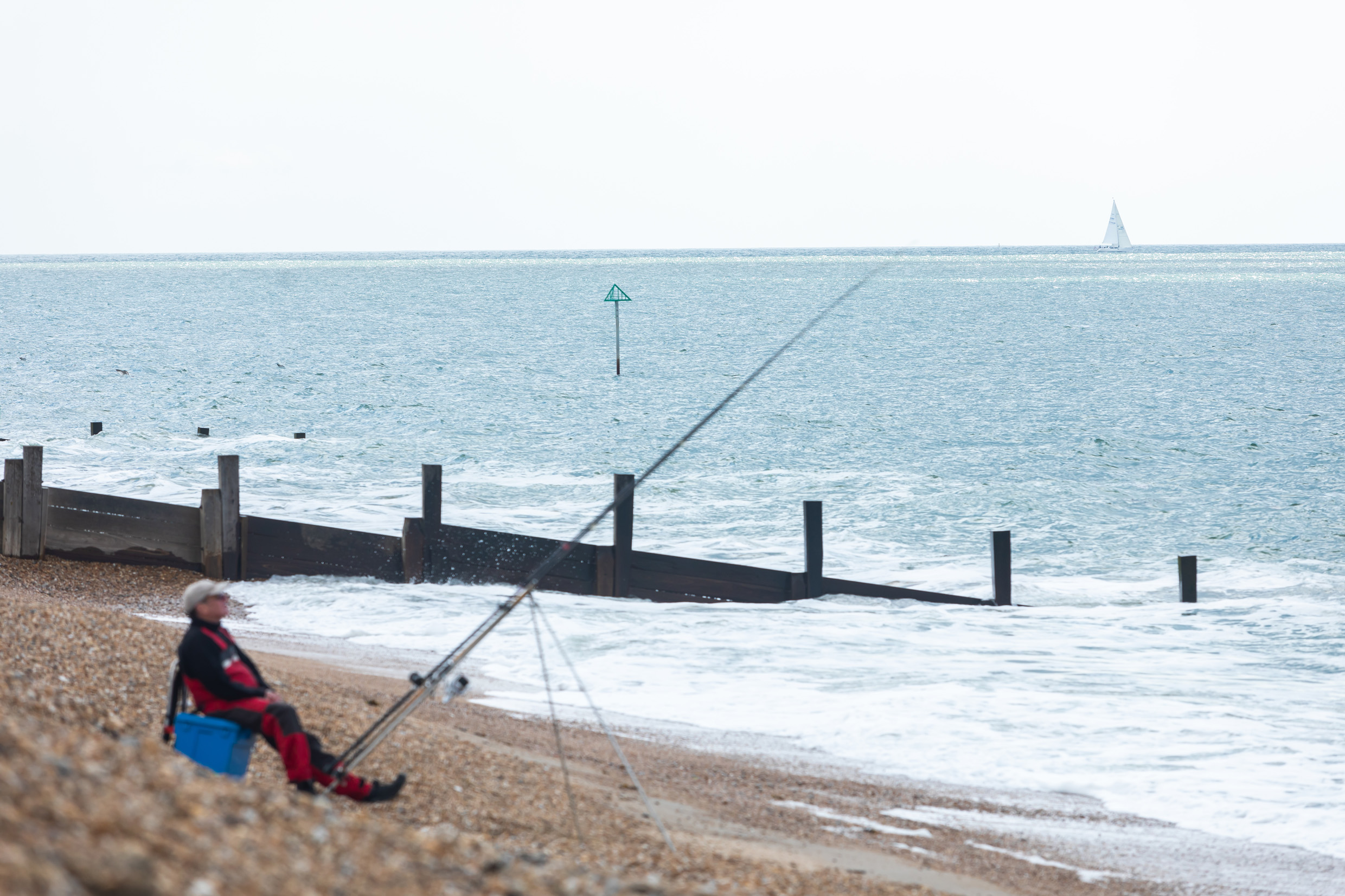 A person fishes at Hayling Island Beach