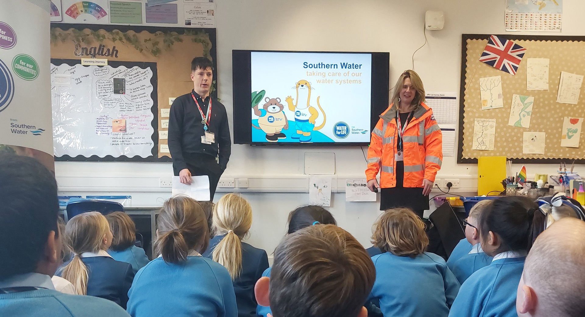 Southern water employees delivering a presentation infront of a class of schoolchildren