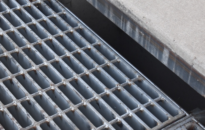 A close-up of the grills of a surface water sewer drain