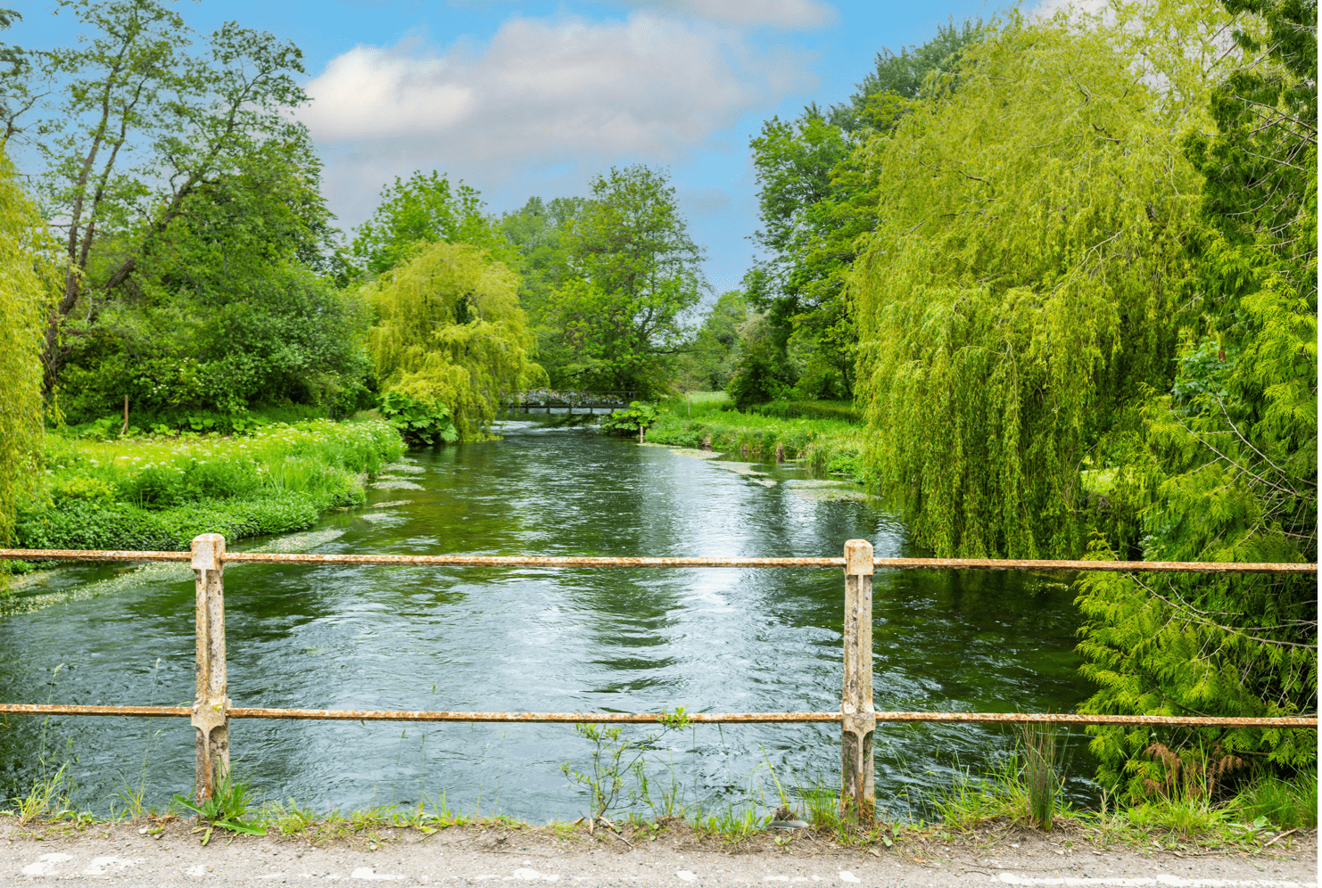 A photo taken from a bridge over a river looking downstream