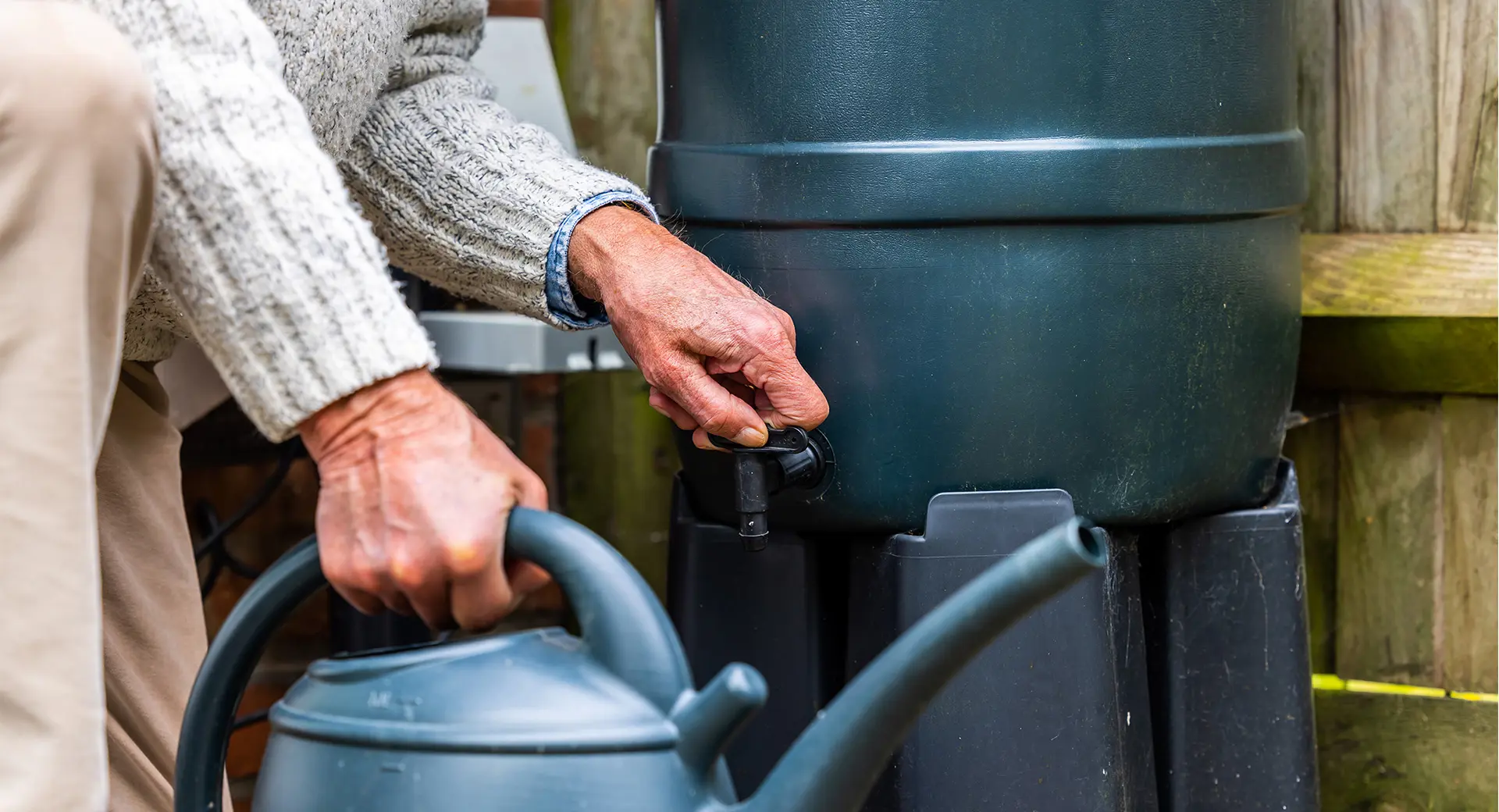 An elderly customer filling a watering can with water