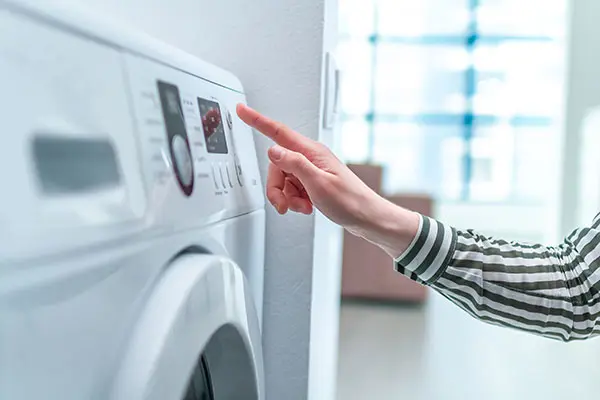 A person operating a washing machine