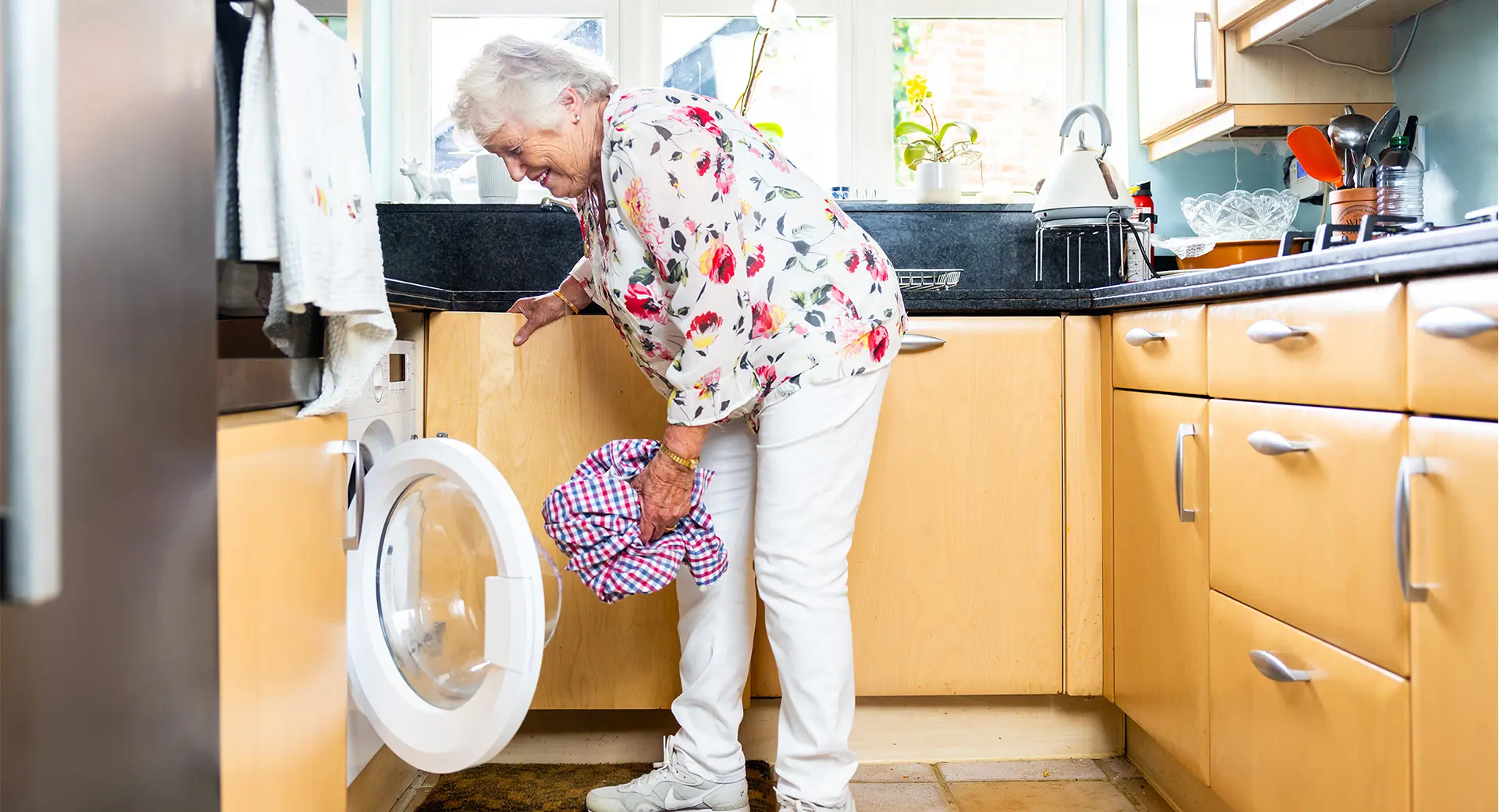 An elderly customer filling a washing machine