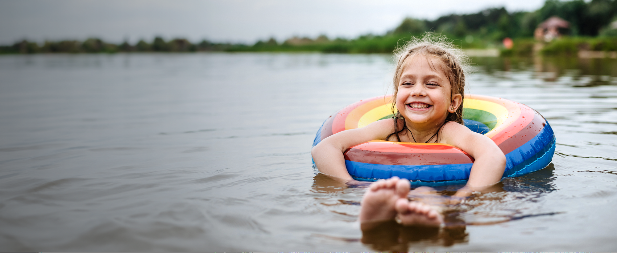 A smiling child in a rubber ring in a lake