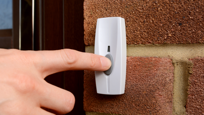 A person ringing a doorbell